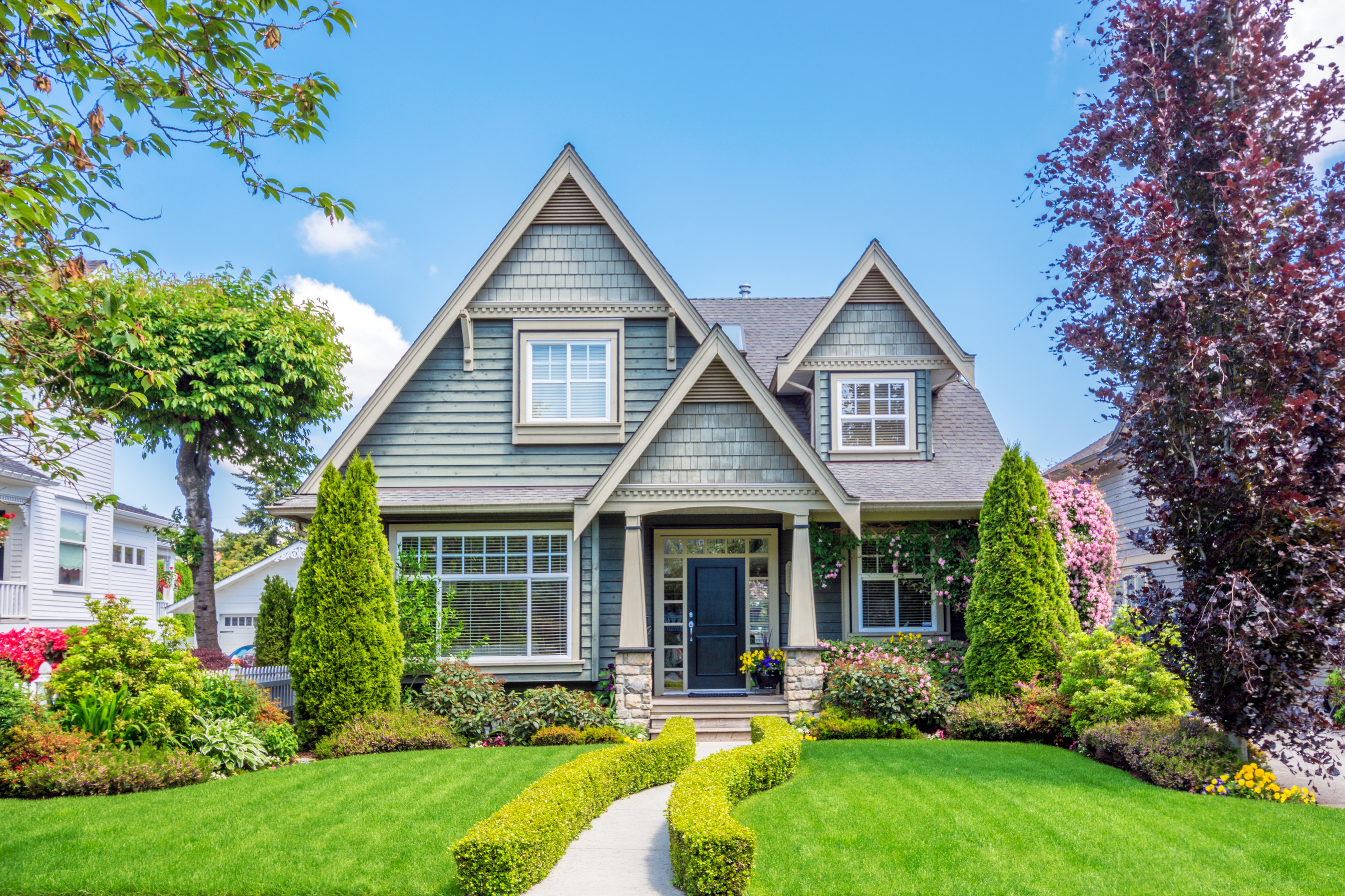 Neighborhood home with well groomed green grass.