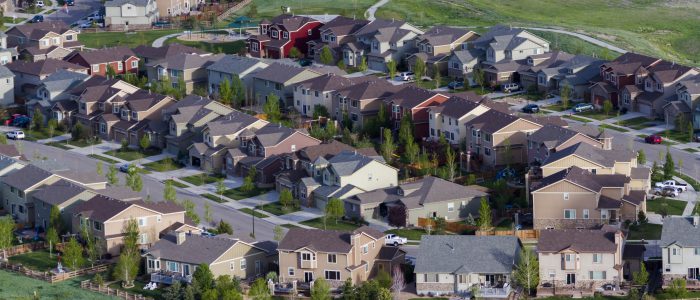 Grouping of houses close together from an aerial view with a pond in the summertime.