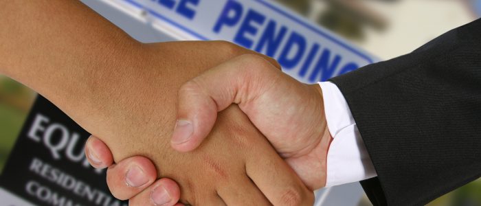 People shaking hands in a real estate transaction