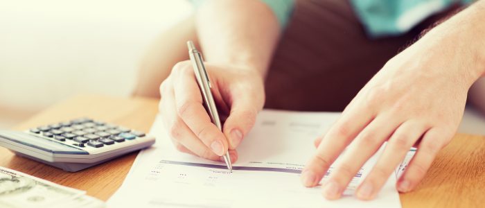 savings, finances, economy and home concept - close up of man with calculator counting money and making notes at home
