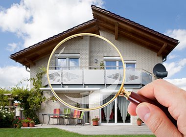 Magnifying Glass in focus looking at a home