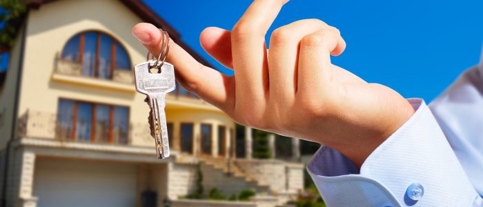 House owner/real estate agent giving away the keys - house out of focus