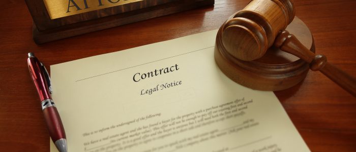 Legal contract with gavel and Attorney name plate on a desk