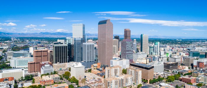 Aerial Drone view high above Denver , Colorado Downtown Skyline Cityscape August 2018 August Summer in the Mile High City Skyscrapers rise up in front of the Rocky Mountains and Colorado State Capitol building