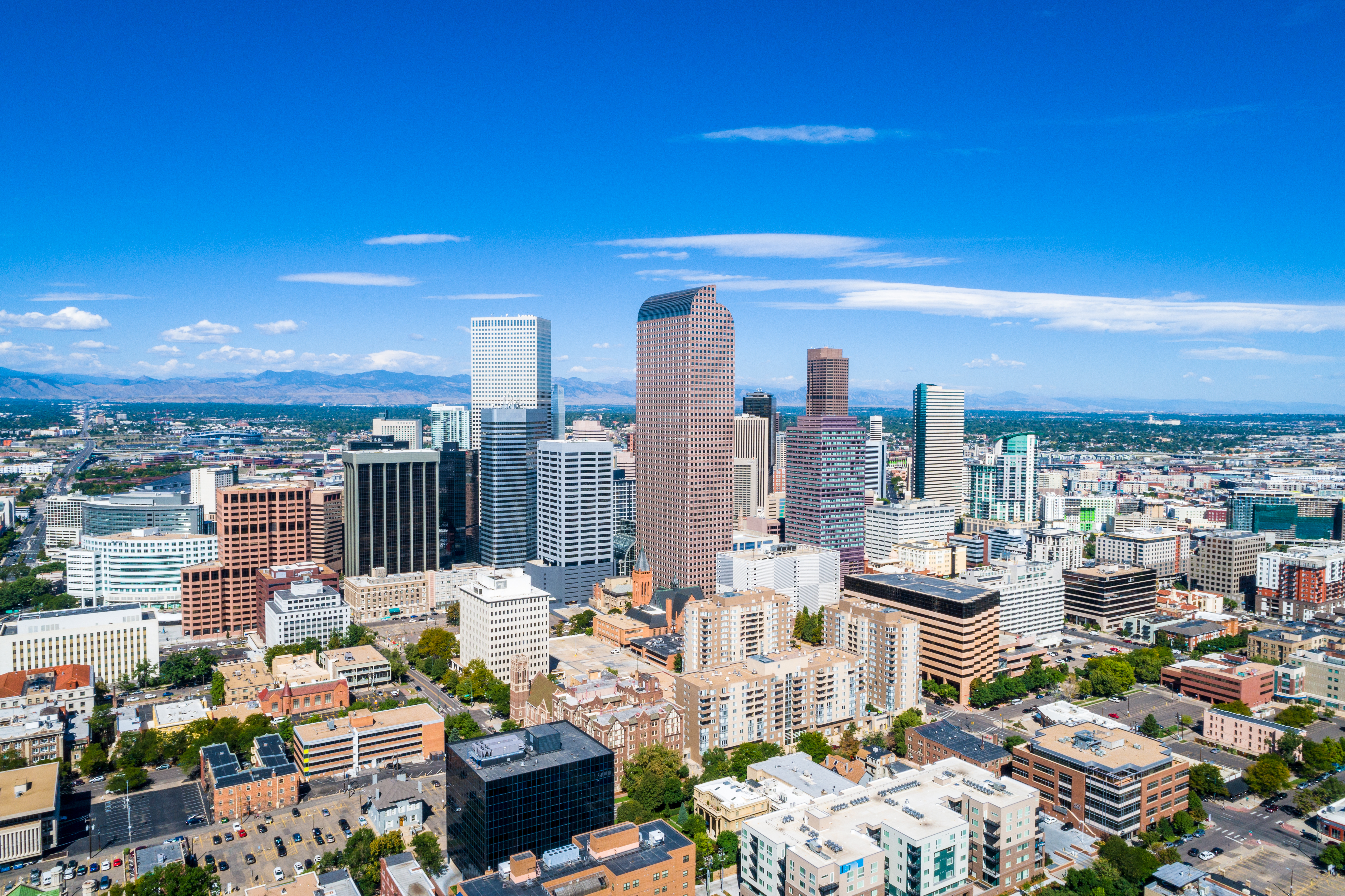 Aerial Drone view high above Denver , Colorado Downtown Skyline Cityscape August 2018 August Summer in the Mile High City Skyscrapers rise up in front of the Rocky Mountains and Colorado State Capitol building