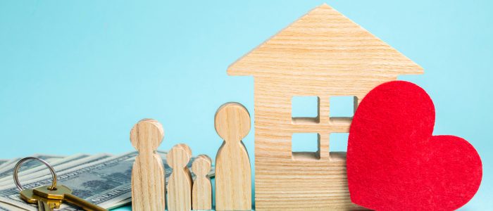 Family stands near the house. Affordable housing. Real estate concept. Buying and selling homes. Rent apartment. Sale of property. Mortgage and payment of taxes. Debt and loan. Purchase. Home sold.