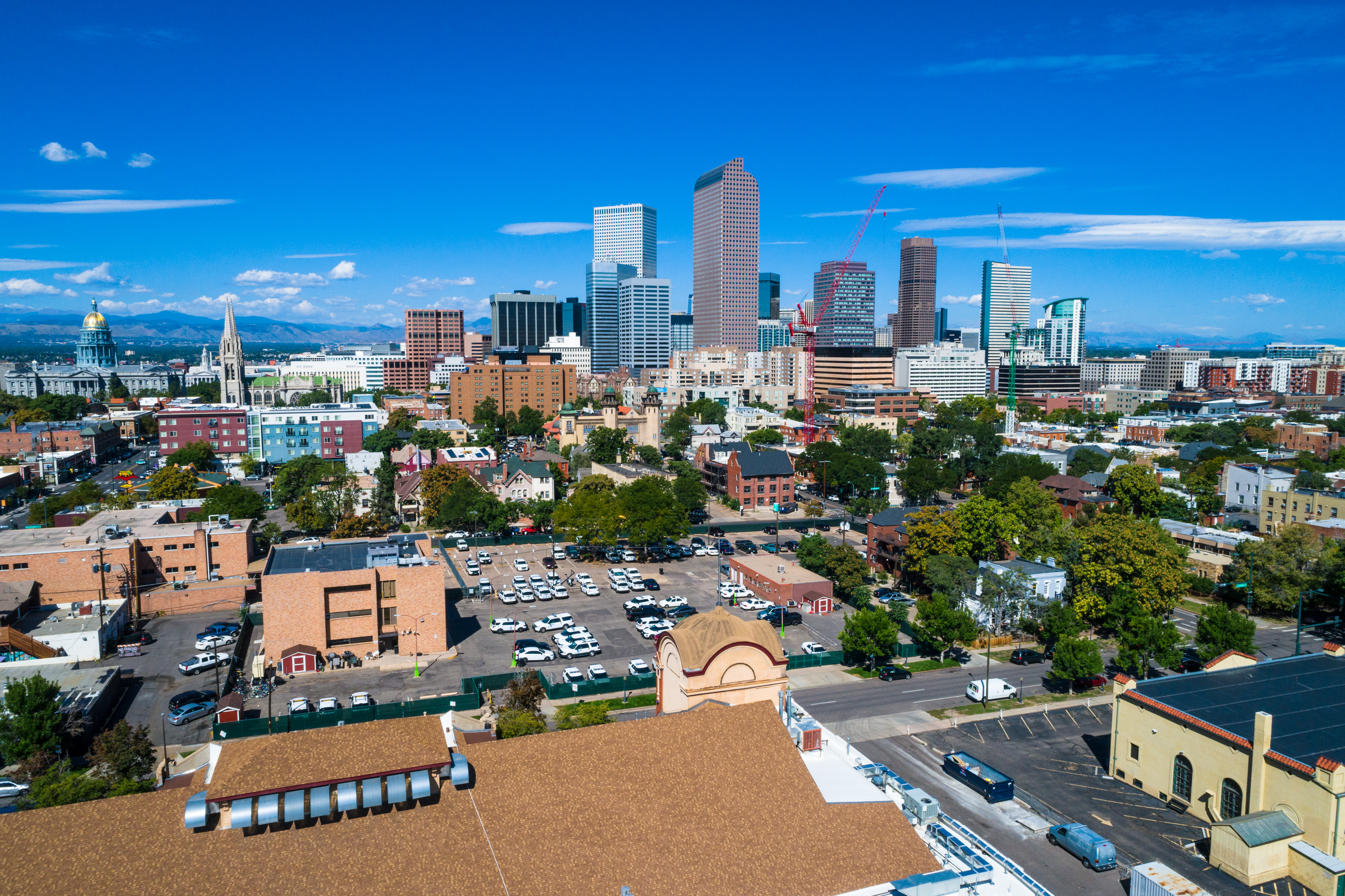 Denver , Colorado Skyline Rises in the Middle of entire City view from historic buildings , to modern , to the State capitol building , all the way to the Rocky Mountains on a perfect summer sunny morning 2018 aerial drone view