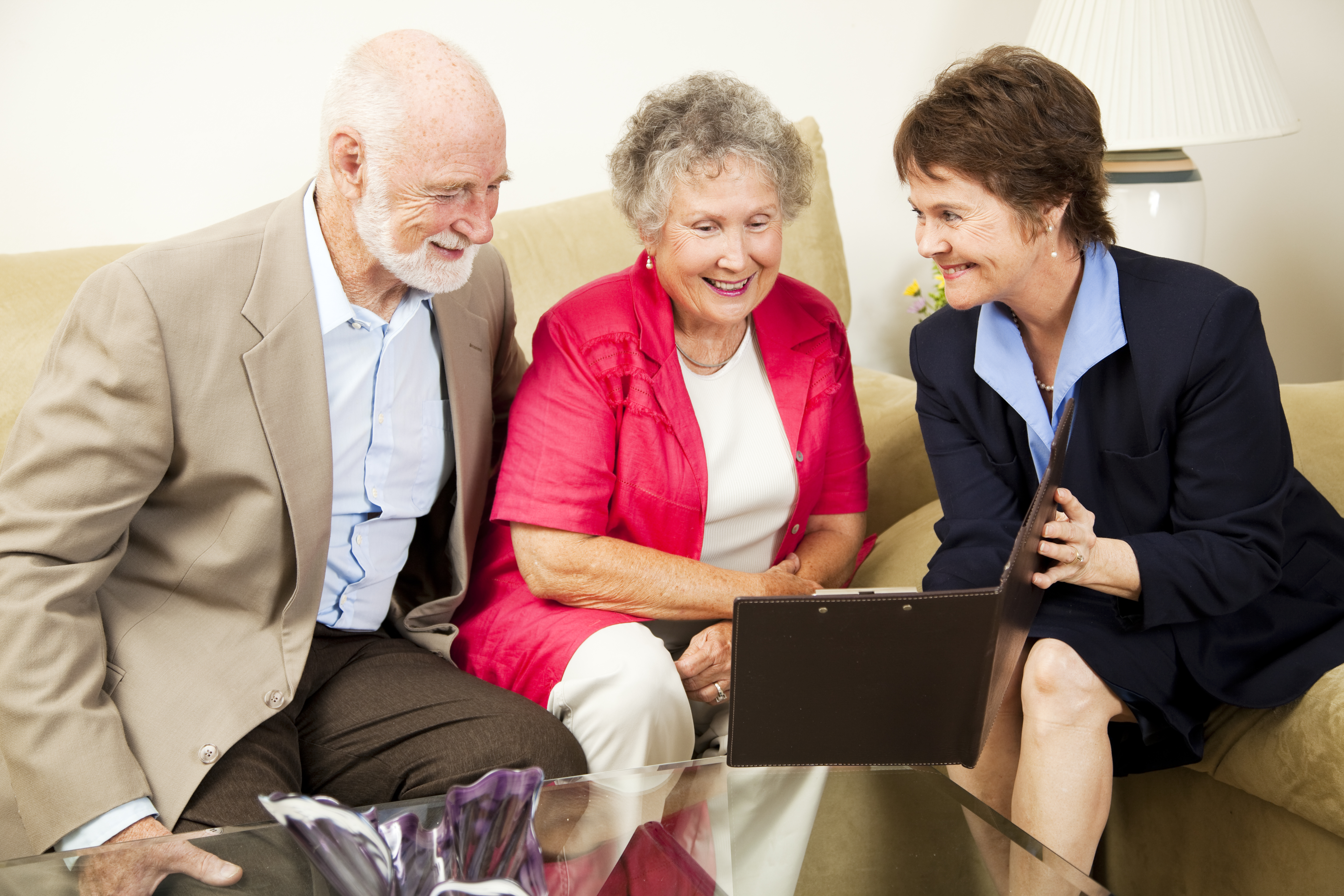 Saleswoman meets with senior couple in their home. Could be real estate life insurance etc.